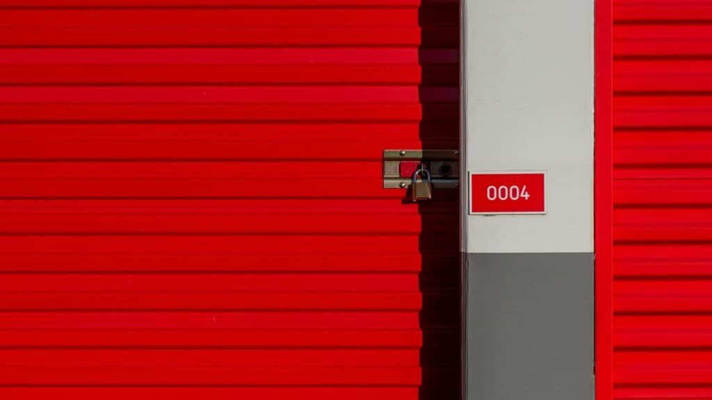 Puerta roja de un módulo de trastero en alquiler con candado y número identificativo