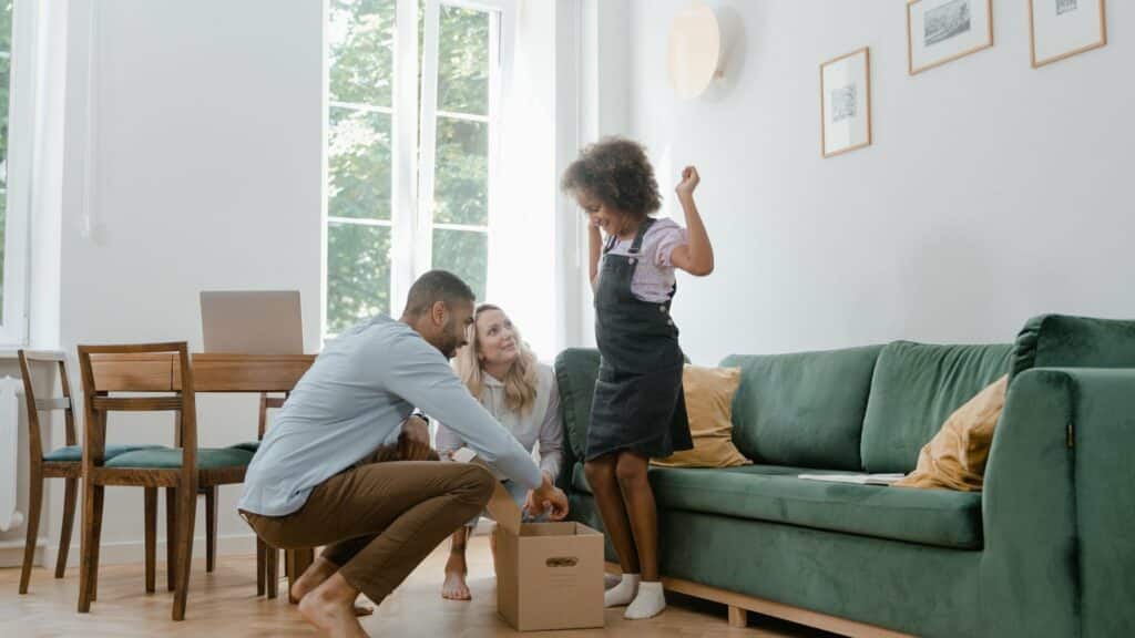 Familia desembalando cajas en el salón de su nueva vivienda